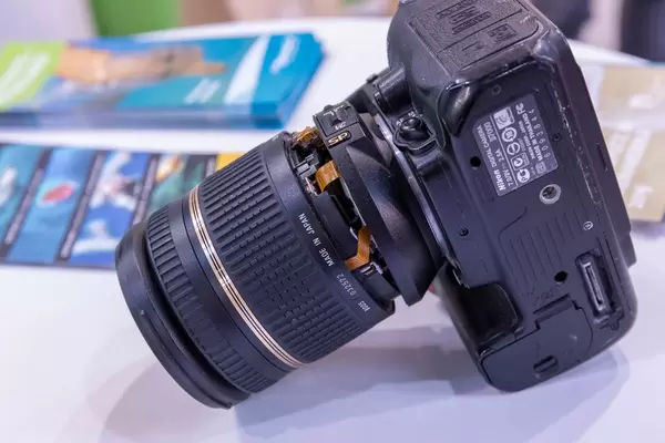 Nahaufnahme Spiegelreflexkamera mit abgebrochenem Objektiv auf weißem Tisch