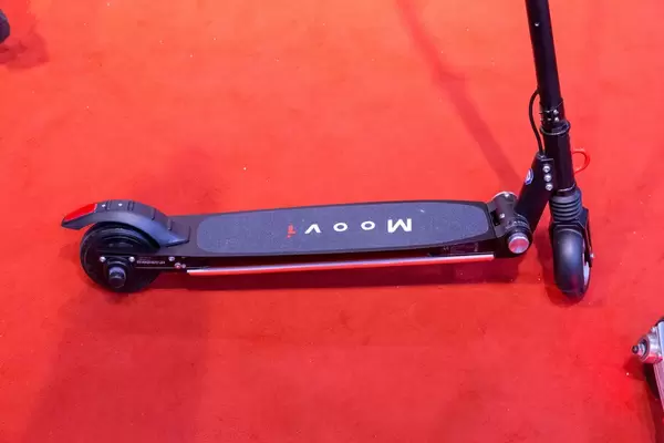 Nahaufnahme Stehfläche von klappbarem E-Scooter von Moovi auf rotem Teppich