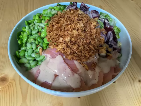 Nahaufnahme vom Salmon Bowl mit Lachs, rote Beete, Edamame, Röstzwiebeln und Soja-Sesam Soße in Simons Stub'n Restaurant in München