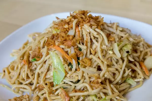 Nahaufnahme von angebratenen Asia-Nudeln mit gebratenem Ei und viel Gemüse, als vegetarisches Mittagessen