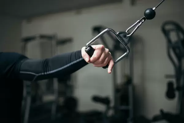 Nahaufnahme von Arm, der Zug auf Fitnessgerät für Brustmuskeln gibt