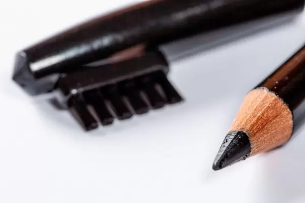 Nahaufnahme von Augenmakeup mit Augenbrauenstift und Augenbrauenbürste