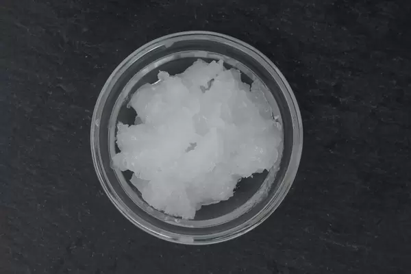 Nahaufnahme von Bio-Kokosöl in Schälchen auf schwarzem Hintergrund