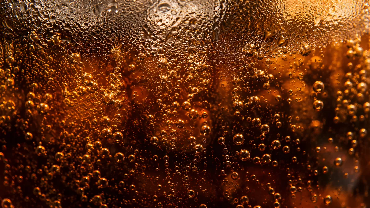 Nahaufnahme von Cola mit Eiswürfeln und Kohlensäureblasen