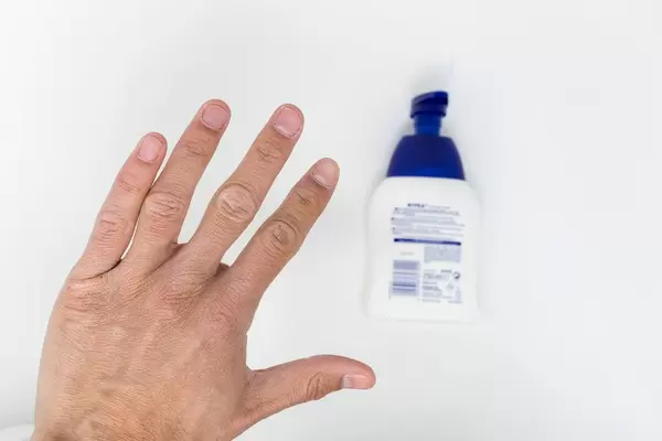 Nahaufnahme von einer Hand mit Flüssigseife im Hintergrund