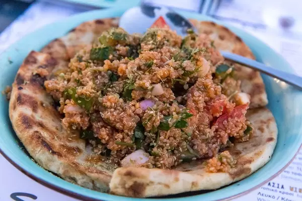 Nahaufnahme von Fladennbrot mit Quinoa-Tamboule mit aromatischen Tomaten aus Paros, Griechenland