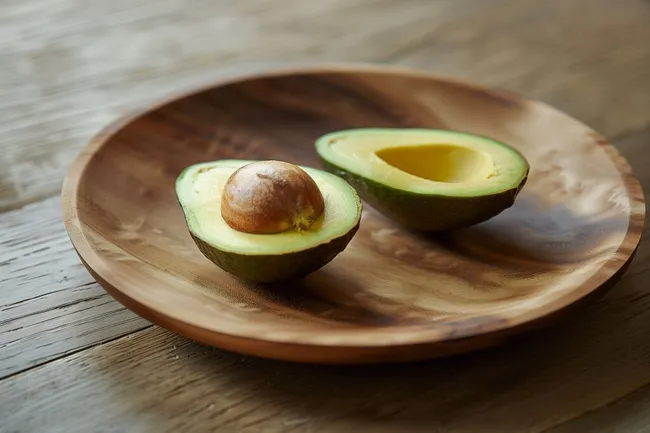 Nahaufnahme von frischen Avocados auf hölzernem Teller