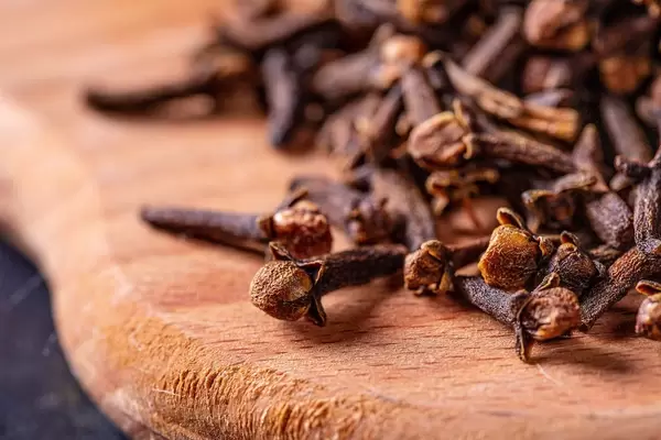 Nahaufnahme von ganzen, getrockneten Gewürznelken auf Holzbrett