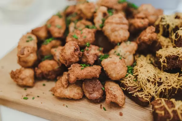 Nahaufnahme von gebratenen Hünchensnacks auf einem Holzbrett