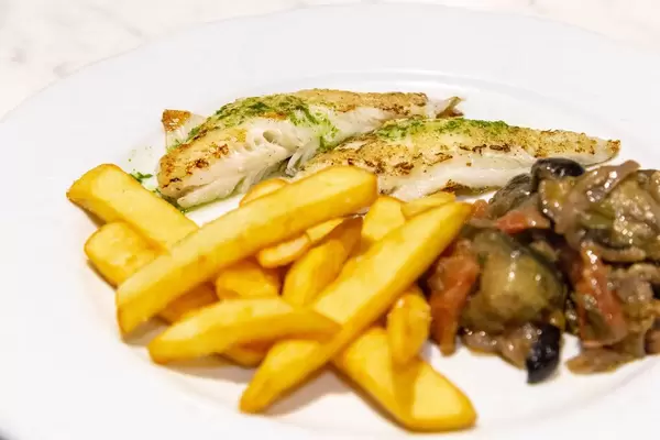 Nahaufnahme von gegrilltem Schnapperfilet mit Pommes und Gemüse