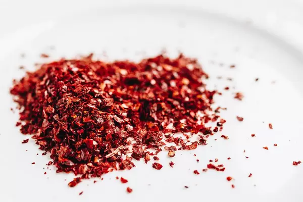 Nahaufnahme von gemahlen roten Paprika vor weißem Hintergrund