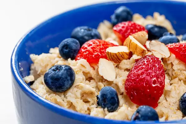 Nahaufnahme von Haferbrei mit Heidelbeeren, Mandeln und Erdbeeren