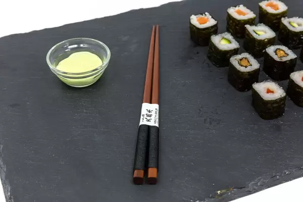 Nahaufnahme von japanischen Essstänchen mit Sushi und Wasabi
