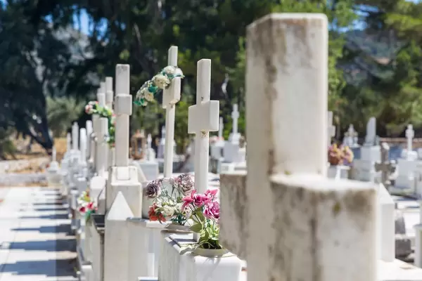 Nahaufnahme von Marmorgräbern mit Kreuzen und Blumen: Agios Charalampos Friedhof auf Naxos