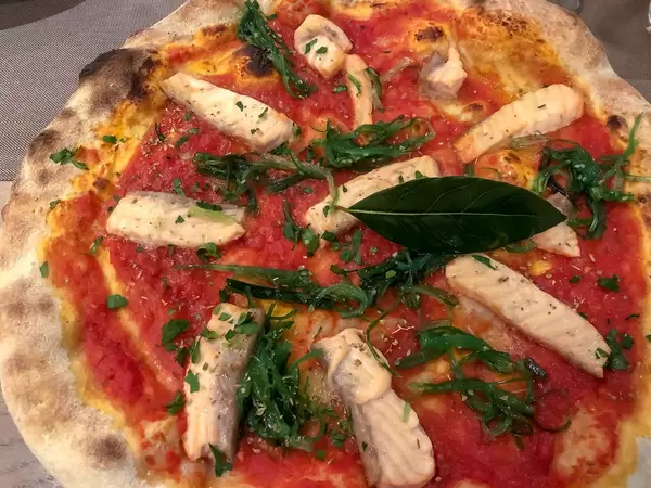 Nahaufnahme von nährstoffreicher Pizza mit Stücken aus Lachs und Algen