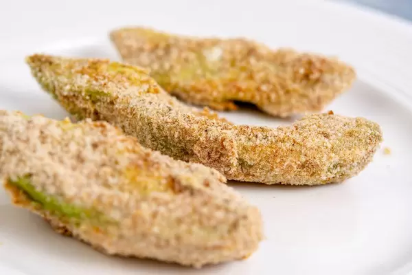 Nahaufnahme von panierten Avocado Snacks auf einem weißen Teller