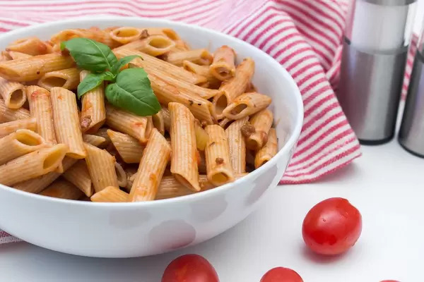 Nahaufnahme von Pasta mit Tomatensoße, dekoriert mit frischem Basilikum