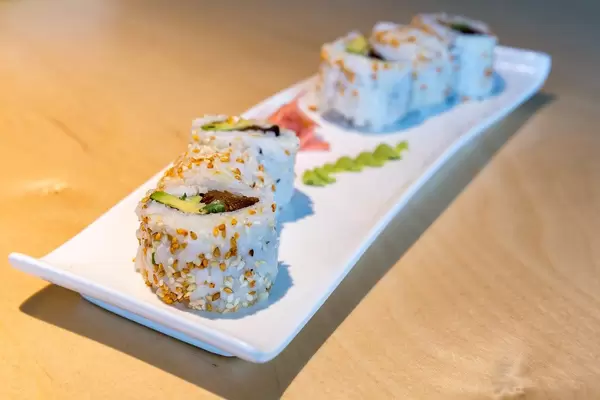 Nahaufnahme von pflanzlichem Sushi "Lucky No Meat" als fleischlose Mahlzeit, mit Tofu, Seitan, süßer Soße, Sesam, vegane Mayo und Röstzwiebeln