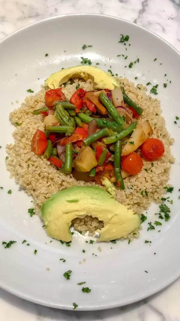 Nahaufnahme von Quinoa mit blanchiertem Gemüse und Avocado