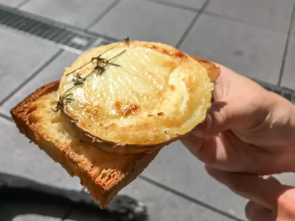 Nahaufnahme von rundem gratiniertem Ziegenkäse mit Thymian-Kräuter auf Pane Siciliano Brot aus dem Clubhaus-Restaurant des 1.FC Köln "Geißbockheim"