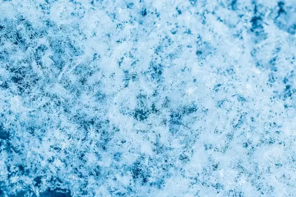 Nahaufnahme von Schneeflocken mit hellblauem Akzent – ideal für Winter Hintergrund