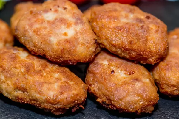 Nahaufnahme von selbstgemachten Schnitzeln aus knusprig gebratenem Fleisch vor dunklem Hintergrund