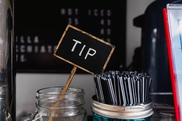 Nahaufnahme von Trinkgeld-Glas neben Strohhalmen im Beanbrewing Café auf den Philippines