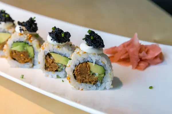 Nahaufnahme von veganem Sushi  und japanischer Hauptspeise "Lucky No Fish" mit Avocado, Kimchi-Sesam, veganem Thunfisch & veganem Kaviar