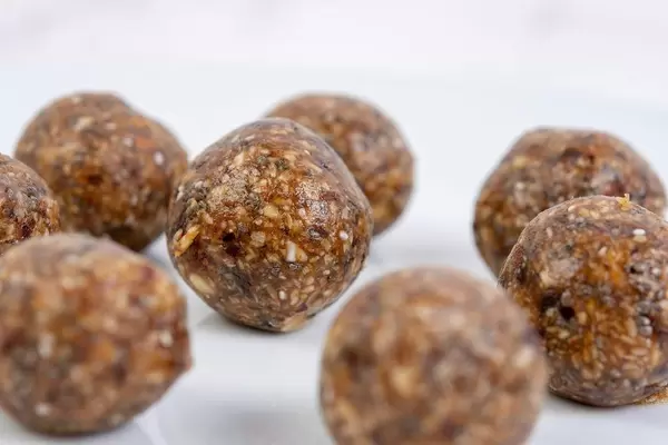 Nahaufnahme von veganen Energiekugeln auf weißem Hintergrund