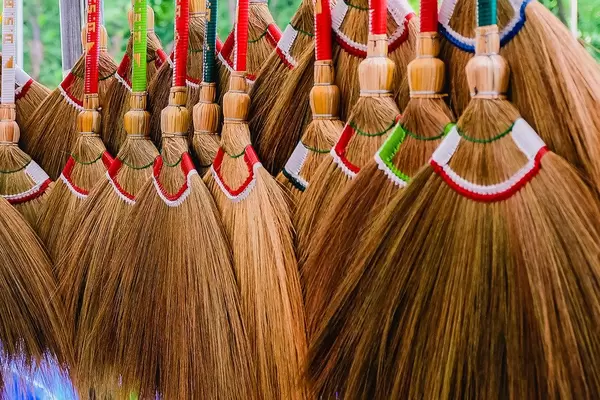 Nahaufnahme von vielen, farbenfrohen Besen aus Reisig