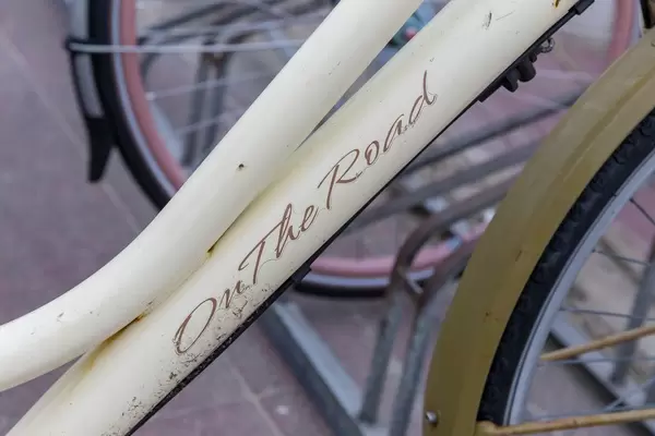 Nahaufnahme von weißem Fahrrad mit der Aufschrift ON THE ROAD