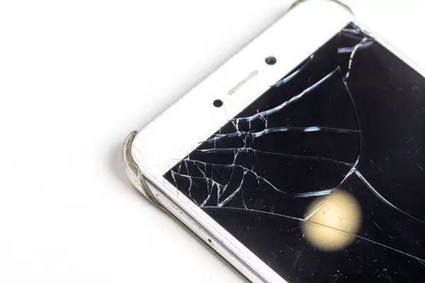 Nahaufnahme von weißem Telefon mit defektem Bildschirm