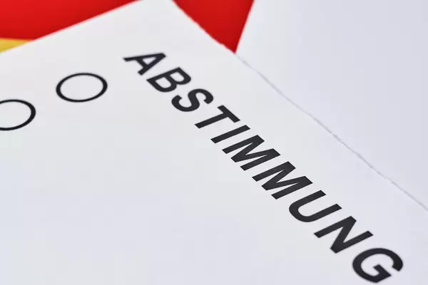 Nahaufnahme von weißem Zettel mit der Schrift "Abstimmung" für die Wahl
