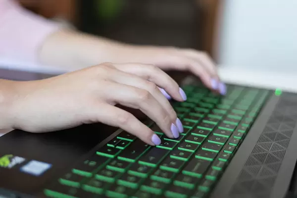 Nahaufnahme weiblicher Hände, auf einem Laptop tippend