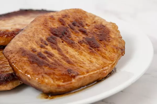 Nahaufnahme zeigt fertiges, gebratenes Schweinefleisch auf einem Teller