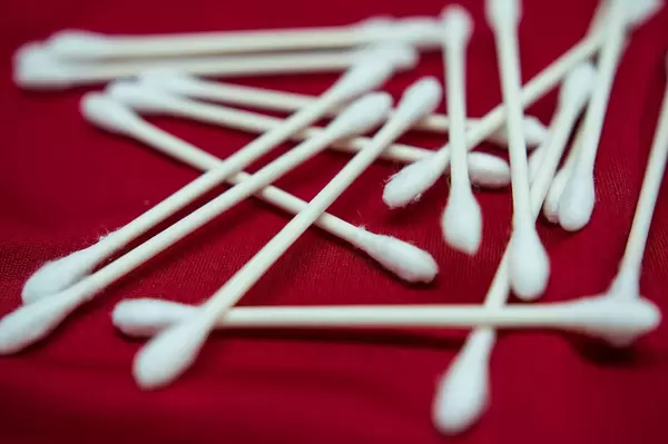 Nahaufnahme zeigt sterile Wattestäbchen auf einer roten Stoffunterlage