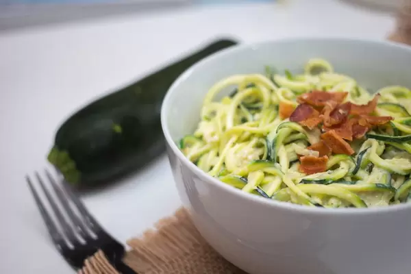 Nahaufnahme - Zucchini Nudeln - Zoodles - mit knusprigem Speck