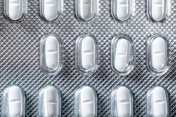 Nahe Aufnahme von oben auf Tablettenpackung mit länglichen weißen Pillen mit medizinischer Wirkung