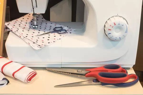 Nähmaschine, Scheren und Stoff