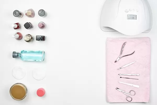 Nail polishes, UV lamp and various accessories and tools for manicure on white background