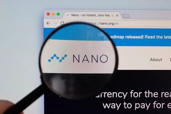 Nano-Logo am PC-Monitor, durch eine Lupe fotografiert