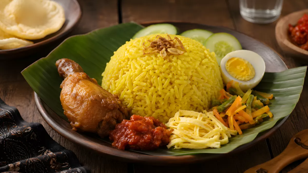 Nasi Kuning mit Hähnchen, Ei und Sambal auf Bananenblatt