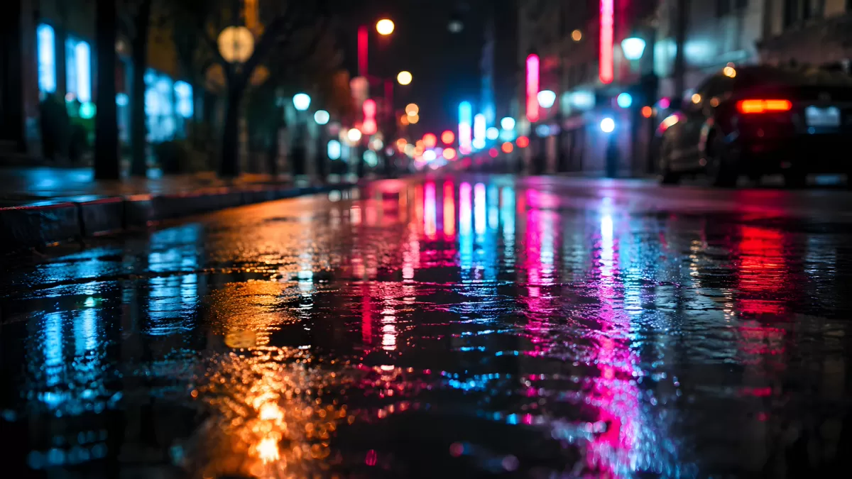 Nasse Stadtstraße bei Nacht mit Neonlicht-Reflexionen