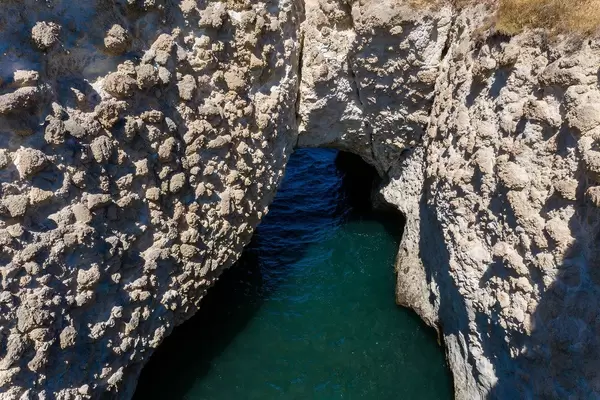 Natural arch and other stunning rock formations near Pachena on Milos, Greece