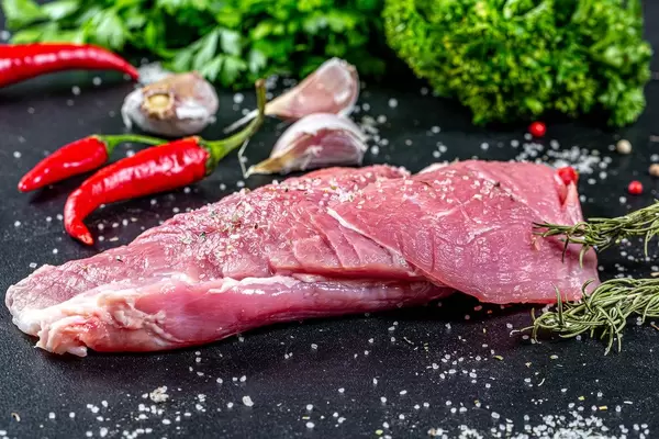 Natural spices and raw meat on black background