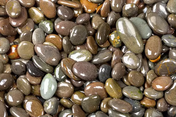 Naturally polished dark rock pebbles background (Flip 2019)