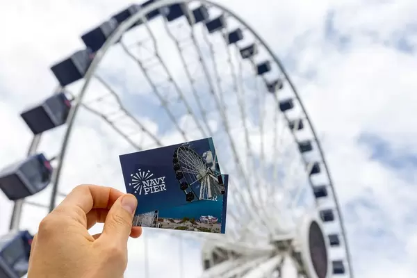 Navy Pier Freizeitpark: Mann hält Eintrittskarten  in der Hand, mit großem Riesenrad im Hintergrund