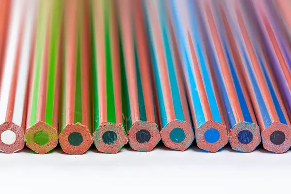 Neue, Nicht gespitzte Bleistifte in Blau- und Grüntönen, vor weißem Hintergrund