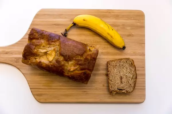 Neue Werte Bananenbrot Apfel und Zimt auf einem Holzschneidebrett top-view