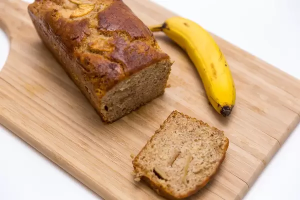Neue Werte Bananenbrot Apfel und Zimt auf einem Holzschneidebrett